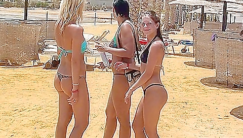 Two blonde beach sluts with tattoos on them take off their bikini